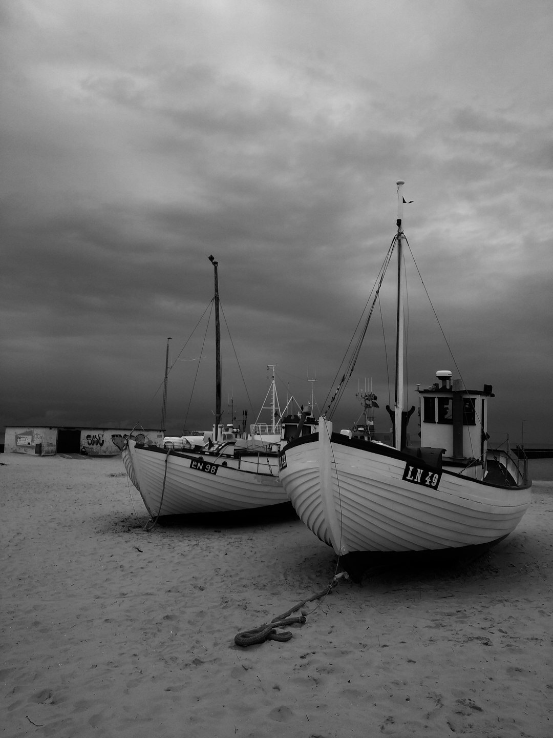 Weathered wooden fishing boats stacked on a Danish beach